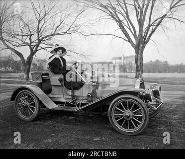 États-Unis : c. 1908 Une femme assise dans une automobile dans un parc. Banque D'Images