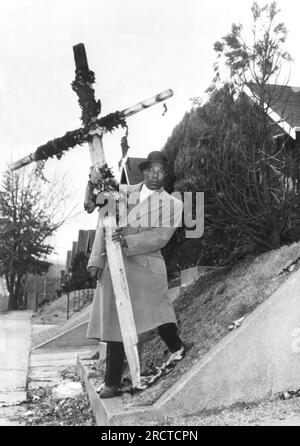 St. Louis, Missouri : 8 décembre 1960 Leon Butler tient une croix carbonisée qui a été brûlée sur sa pelouse avant dans le dernier d'une série d'événements harcelants depuis que sa famille a emménagé dans un quartier blanc il y a quatre semaines. Banque D'Images