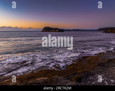 Vue sur l'océan au lever du soleil depuis la réserve Paul Landers surplombant Lion Island depuis Pearl Beach sur la côte centrale, Nouvelle-Galles du Sud, Australie. Banque D'Images