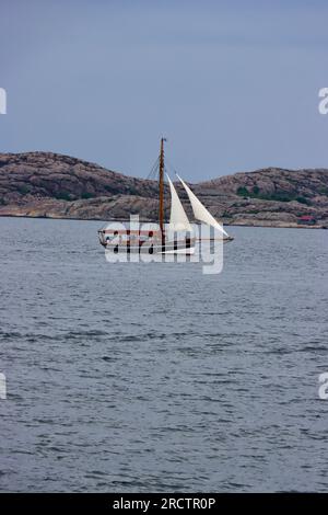 Vieux voilier passant des îles sur la côte ouest de la Suède Banque D'Images