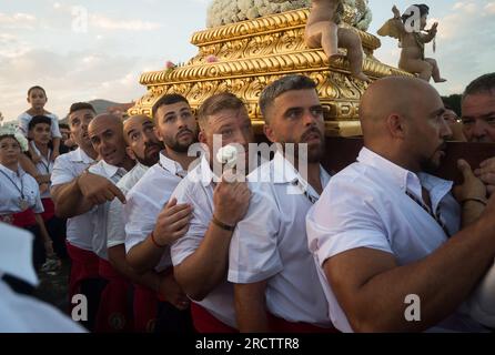 Malaga, Espagne. 16 juillet 2023. Les pénitents de la fraternité 'Virgen del Carmen' sont vus portant la statue de la vierge sur la plage alors qu'ils prennent part à une procession dans le quartier 'El Palo'. Chaque année, le 16 juillet, la ville de Malaga célèbre une fête religieuse en l'honneur de la 'Virgen del Carmen', patron des marins et des pêcheurs. La statue de la Vierge, portée par un groupe de croyants en costume traditionnel le long des rues, est placée sur un bateau de la plage, qui plus tard navigue le long de la côte de Malaga. (Photo Jesus Merida/SOPA Images/Sipa USA) crédit : SIPA USA/Alamy Live News Banque D'Images