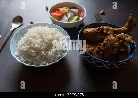 Déjeuner indien riz vapeur et curry de poulet servis. Banque D'Images