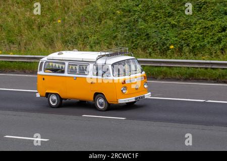 Années 1977 70 Seventies Volkswagen Motor Caravan Yellow LCV essence 1584 cc voyageant à grande vitesse sur l'autoroute M6 dans le Grand Manchester, Royaume-Uni Banque D'Images