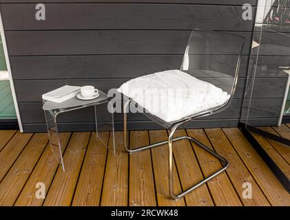 Meubles en acrylique moderne transparent transparent dans la maison. Chaise avec oreiller, table d'appoint avec tasse à thé et livre. Concept de matériau de meuble alternatif. Banque D'Images