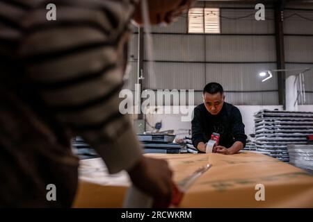 Kunming, province chinoise du Yunnan. 7 avril 2023. Mao Guangyou emballe un matelas «Truck Baby» pour livraison dans le comté de Fuyuan de la ville de Qujing, dans la province du Yunnan, au sud-ouest de la Chine, le 7 avril 2023. Mao Guangyou a consacré d'innombrables nuits au cours de la dernière décennie à naviguer dans son camion à travers les hautes montagnes de Chine. Lorsqu'il se sentait endormi, il s'arrêtait le long de son voyage et trouvait réconfort et répit sous la vaste étendue du ciel étoilé.POUR ALLER AVEC «à travers la Chine : un ancien chauffeur de camion rêve grand sur la route d'un voyage reposant» crédit : Hu Chao/Xinhua/Alamy Live News Banque D'Images