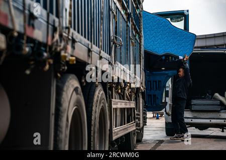 Kunming, province chinoise du Yunnan. 7 avril 2023. Mao Guangyou met un matelas "Truck Baby" dans la cabine d'un camion dans le comté de Fuyuan de la ville de Qujing, dans la province du Yunnan, dans le sud-ouest de la Chine, le 7 avril 2023. Mao Guangyou a consacré d'innombrables nuits au cours de la dernière décennie à naviguer dans son camion à travers les hautes montagnes de Chine. Lorsqu'il se sentait endormi, il s'arrêtait le long de son voyage et trouvait réconfort et répit sous la vaste étendue du ciel étoilé.POUR ALLER AVEC «à travers la Chine : un ancien chauffeur de camion rêve grand sur la route d'un voyage reposant» crédit : Hu Chao/Xinhua/Alamy Live News Banque D'Images