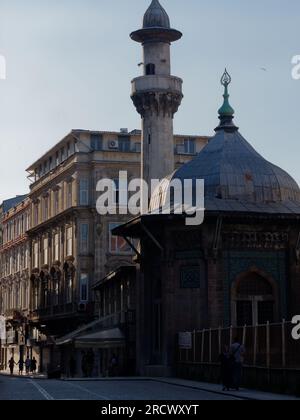 Mosquée dans l'ombre à Istanbul comme un groupe de piétons marchent dans la rue main dans la main en silhouette. Turquie Banque D'Images