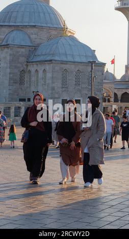 Trois amis marchent devant la mosquée Şemsi Pacha un soir d'été à Uskudar, du côté asiatique d'Istanbul, en Turquie Banque D'Images