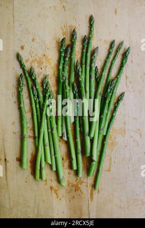 Bouquet d'asperges de jardin fraîchement coupées sur une planche à découper en bois Banque D'Images