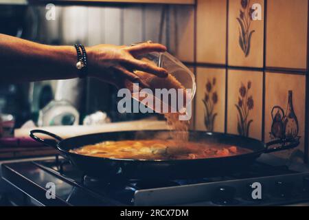 Cuisiner la paella espagnole à la maison. Banque D'Images