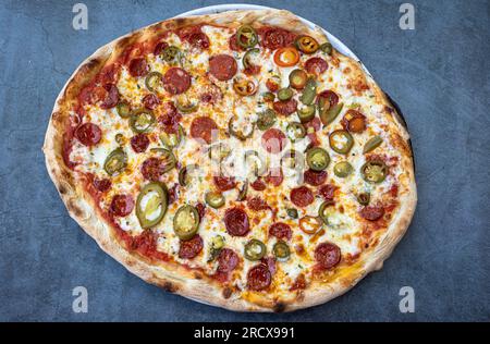 Pizza mexicaine à base de chorizo, oignon et jalapeños sur un fond rustique. Vue de dessus pizza italienne avec une touche mexicaine Banque D'Images