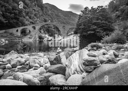 Zen petit tas de pierres, point de vue peu profond devant le pont du Diable sur la rivière Arda, Bulgarie du Sud. Photo de voyage en noir et blanc Banque D'Images