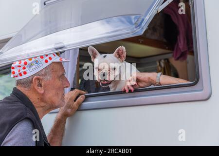 Col du Tourmalet, France - juillet 06 2023 : vieil homme jouant avec son chien lors de l'étape 6 du Tour de France 2023. Banque D'Images