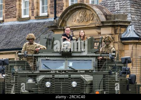 Redford Barracks, Édimbourg, Écosse, Royaume-Uni, 17 juillet 2023. Army at the Fringe : artistes d'un spectacle au Festival Fringe d'Édimbourg membres de la distribution CTRL Room (sur le rôle de l'IA dans la guerre) avec des soldats camouflant dans la jungle des fusils du 3e bataillon avec un énorme véhicule Mastiff lourdement blindé conçu pour contrer les menaces des bombes de bord de route. Crédit : Sally Anderson/Alamy Live News Banque D'Images