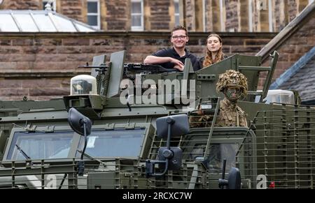 Redford Barracks, Édimbourg, Écosse, Royaume-Uni, 17 juillet 2023. Army at the Fringe : artistes d'un spectacle au Festival Fringe d'Édimbourg membres de la distribution CTRL Room (sur le rôle de l'IA dans la guerre) avec des soldats camouflant dans la jungle des fusils du 3e bataillon avec un énorme véhicule Mastiff lourdement blindé conçu pour contrer les menaces des bombes de bord de route. Crédit : Sally Anderson/Alamy Live News Banque D'Images