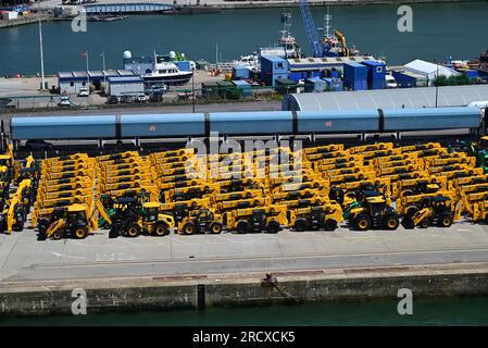 Un train porte-voitures et des JCB jaunes sur le quai des quais de Southampton. Banque D'Images