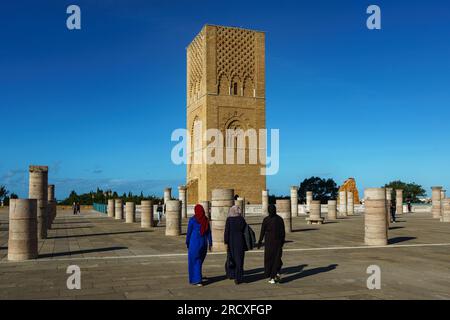 Maroc. Rabat. Un groupe de femmes se promènent devant la magnifique Tour Hassan et ses colonnes de pierre sur l’esplanade Yacoub al-Mansour. La tour est l'in Banque D'Images