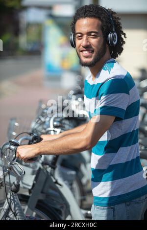 jeune étudiant attrayant loue un vélo Banque D'Images
