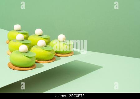Un plateau de beignets verts assortis est posé sur une table en bois Banque D'Images