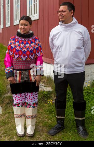 Fille inuite portant le costume national debout avec un homme devant l'église à Qaqortoq, Groenland en juillet Banque D'Images