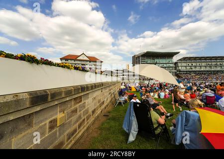 Course de chevaux à York, Angleterre. Les gens assis dans les sièges de pelouse pour voir les courses de chevaux, pique-nique, boire, manger, parier et profiter du temps avec les amis et la famille. Banque D'Images