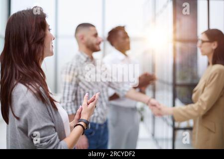 dame qui a réussi applaudit l'accord de ses collègues après les négociations Banque D'Images