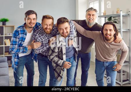 Amis barbus masculins regardant joyeux à la caméra et souriant s'amusant à la maison. Banque D'Images