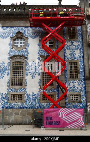 Les travailleurs sur la plate-forme élévée d'ascenseur de ciseaux faisant l'inspection de maintenance sur le côté de l'église d'Igreja do Carmo, Porto / Porto, Portugal Banque D'Images