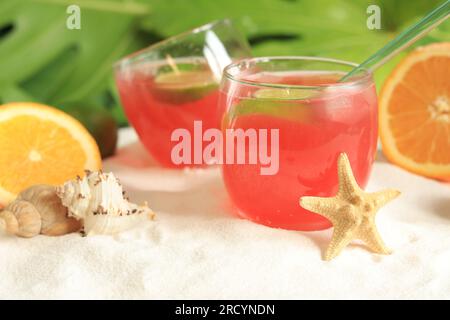 Cocktail alcoolisé de couleur rose près des fruits tropicaux. Boisson fraîche sur la plage. Mise au point sélective Banque D'Images