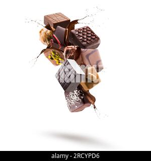 Pralines au chocolat assorties flottant avec une éclaboussure de chocolat fondu sur fond blanc Banque D'Images