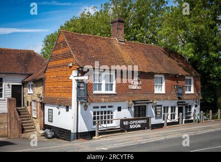 Un grand panneau imprimé sur une feuille de plastique indiquant « Re-opening Soon » apposé à l'avant d'un pub à Billingshurst, West Sussex, Royaume-Uni. Banque D'Images