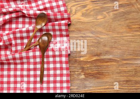 Serviette à carreaux rouges et cuillères sur fond en bois Banque D'Images