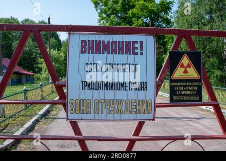 Un panneau de danger d'interdiction de rayonnement à l'entrée de la zone d'exclusion de trente kilomètres au Bélarus Banque D'Images