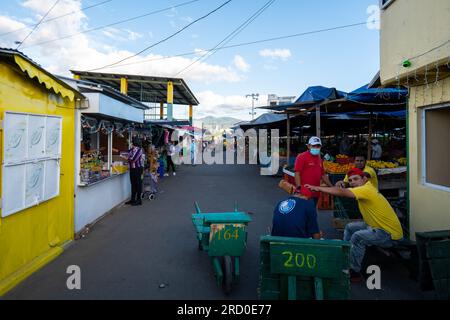 Tegucigalpa, Francisco Morazan, Honduras - 16 décembre 2022 : des ouvriers assis sur des boîtes en bois regardent dans le marché coloré 'Mercado Mayoreo' près de la Nation Banque D'Images