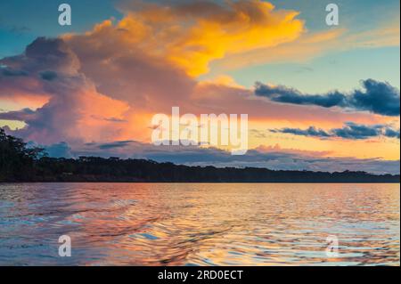 Coucher de soleil éclairant les nuages sur la rivière Madre de Dios au Pérou. Banque D'Images