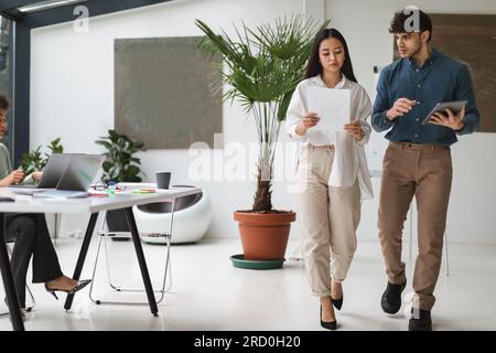 Couple de professionnels divers brainstorming tout en marchant dans le bureau Banque D'Images