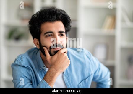 Gros plan Portrait de sérieux bel homme indien avec expression de visage pensive Banque D'Images