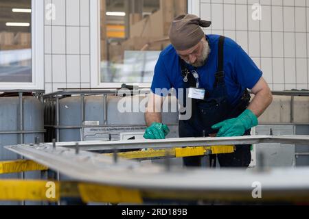 Kassel, Allemagne. 12 juillet 2023. Un employé de Hübner-Werke lave le cadre d’un système de transition de la flotte ICE 3. Le groupe Hübner de Kassel, dans le nord de la Hesse, achève la rénovation des multisegments pour l'ensemble de la flotte ICE 3 de Deutsche Bahn. (À dpa: "Rafraîchissement : modernisation de la flotte ICE 3 proche de l'achèvement") crédit : Swen Pförtner/dpa/Alamy Live News Banque D'Images