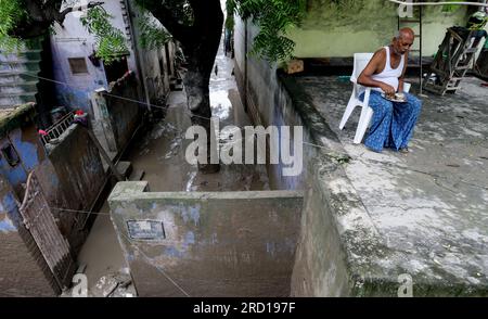 Un homme est vu prendre un repas sur le toit de sa maison alors que les eaux de crue de la rivière Yamuna gonflée reculent, à Yamuna Bazar à New Delhi. Les habitants et les autorités mènent une campagne de propreté dans les zones de basse altitude touchées par les inondations afin de minimiser les maladies d'origine hydrique. Encore une fois, le niveau d'eau Yamuna a atteint 205,93 mètres au-dessus de la marque de danger de 205,33 a déclaré officiel. Le Rover Yamuna a battu un record de 45 ans et a atteint son plus haut niveau de tous les temps de 208,65 le 2023 juillet après de fortes pluies et le déversement d'eau du barrage Hathnikund dans l'Haryana. Banque D'Images