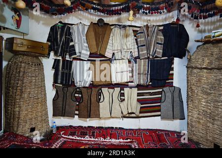 Uludere, Turquie. 15 juillet 2023. Des costumes masculins kurdes de différentes régions sont exposés au Musée ethnographique kurde. Le folkloriste Seyda Goyan, qui a écrit 6 livres sur le folklore kurde, a fondé le « Musée ethnographique kurde Seyda Goyan », où environ un millier d'œuvres ethnographiques sont stockées et exposées de ses propres moyens. Seyda Goyan, qui n’a pas pu trouver de lieu d’exposition pour les œuvres qu’il a recueillies en trois ans, a fait de sa maison historique de 2 pièces un musée dans le quartier d’Uludere, dans la province de Sirnak en Turquie. Crédit : SOPA Images Limited/Alamy Live News Banque D'Images