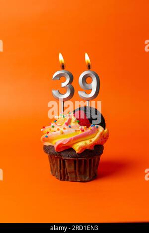 gâteau d'anniversaire avec le numéro 39 - cupcake sur fond orange avec bougies d'anniversaire Banque D'Images