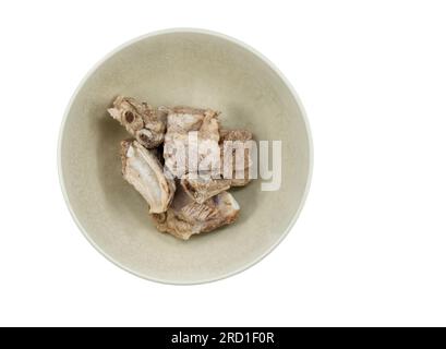 Côtes levées isolées ou os de porc dans un vieux bol sur fond blanc, vue de dessus des côtes levées dans un bol, préparation des côtes levées pour la cuisson Banque D'Images