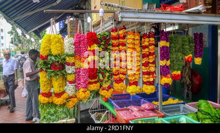 Singapour, Singapour - 21 août 2012. Guirlandes de fleurs colorées utilisées pour le culte hindou exposées à l'extérieur d'une petite boutique dans Little India. Banque D'Images