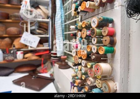 Atelier de fabrication de chapeaux. Gros plan de bobines de fil colorées. Fils multicolores pour couture et travaux d'aiguille Banque D'Images