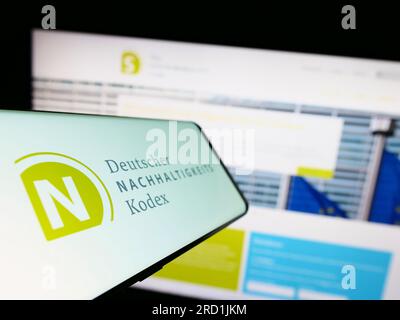 Téléphone portable avec le logo de Deutscher Nachhaltigkeitskodex (DNK) sur l'écran devant le site Web. Concentrez-vous sur le centre gauche de l'écran du téléphone. Banque D'Images
