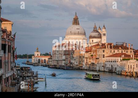 Venise, Italie - 22 juin 2023 : vue imprenable sur le Grand Canal de Venise et la Basilique Santa Maria Della Salute au coucher du soleil. Banque D'Images