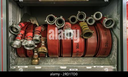 Gros plan des tuyaux de lutte contre l'incendie enroulés dans le stockage Banque D'Images