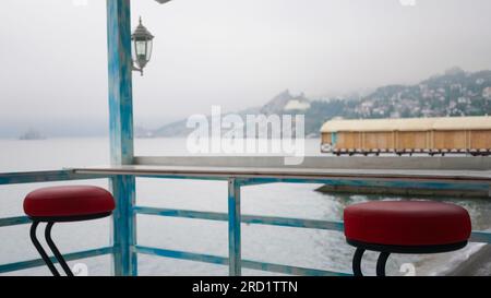 Tabourets de bar sur la terrasse d'été d'un café au bord de la mer Banque D'Images