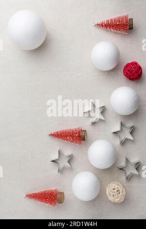 Fond plat pour Noël et nouvel an 2024. Sapins de Noël miniatures décoratifs ; boules de neige ; étoiles argentées ; numéro 2022 sur fond de pierre clair Banque D'Images