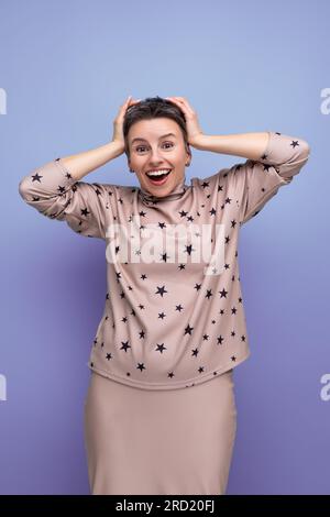 surprise jeune femme européenne aux cheveux gris avec une coupe de cheveux courte dans une jupe et chemisiers se réjouit de gagner Banque D'Images